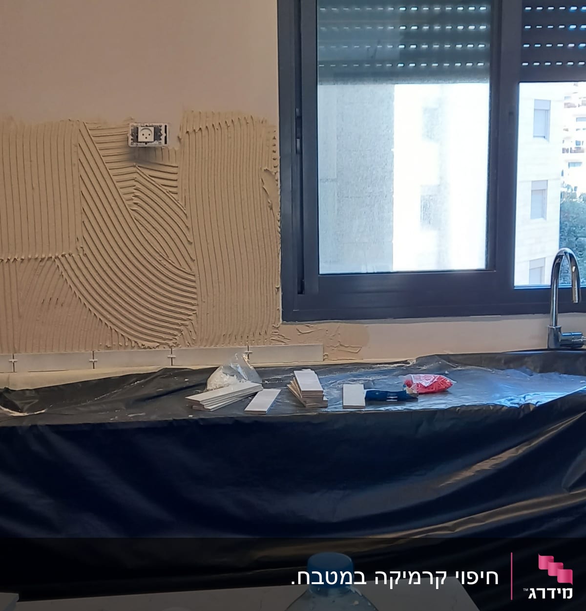 קיר עם טיח מוכן להדבקת אריחים, כלים על השיש